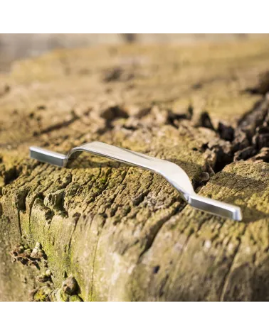 Polished chrome furniture handle GOLDEN design handle showcased on a wooden log