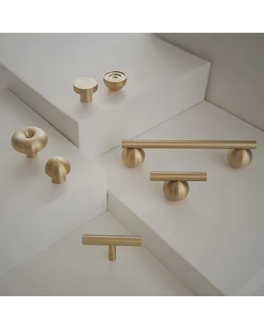 Brass T-Bar cabinet knob design handle placed on a light stepped surface