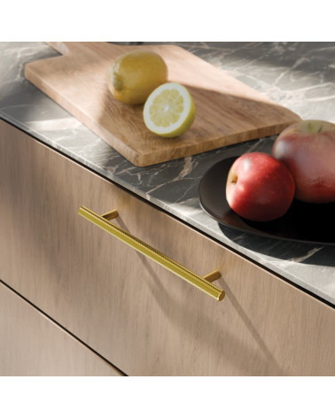 Polished gold CRUSO furniture handle designer handle mounted on a wooden cabinet