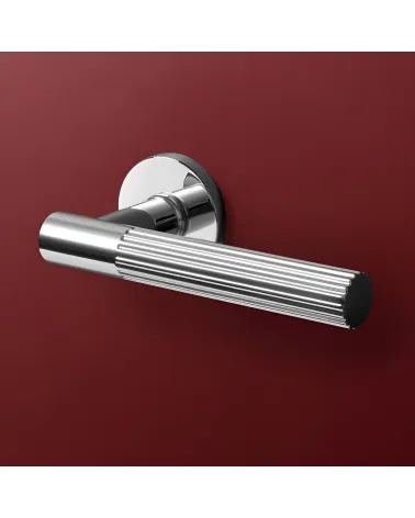 Polished chrome LIVIA door handle designer handle showcased on a background