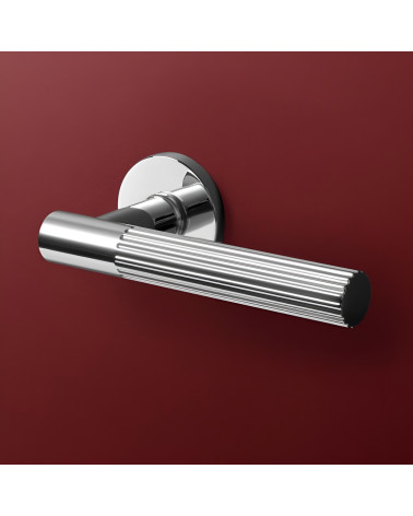 Polished chrome LIVIA door handle designer handle showcased on a background