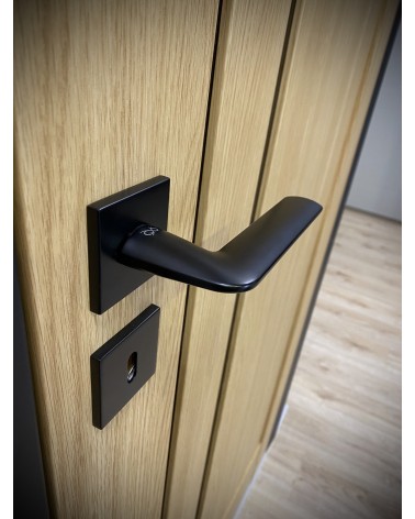 Black STINGER door handle designer handle angled top view mounted on a door
