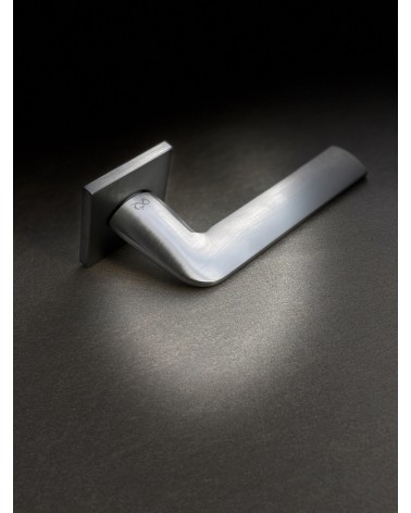 STINGER brushed chrome door handle designer handle placed on an illuminated background