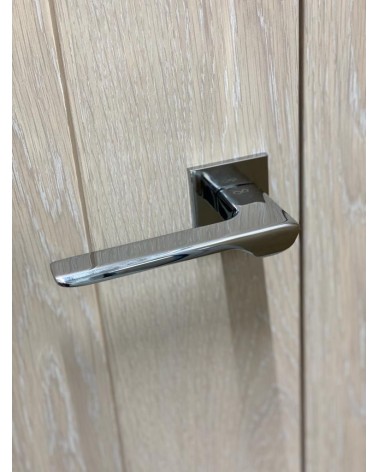 LIGNE polished chrome door handle design handle angled top view mounted on a door