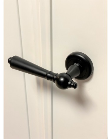 Black MILLENAIRE door handle designer handle angled top view mounted on a door