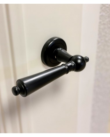 Black MILLENAIRE door handle designer handle top view slightly angled mounted on a door