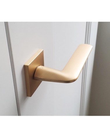 Matt gold STINGER door handle designer handle top view slightly angled mounted on a door