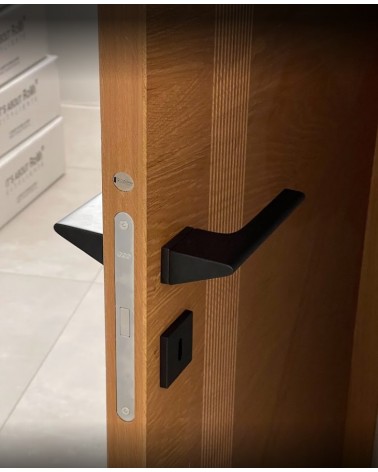 Black LUPINA door handle designer handle mounted on a half-open door
