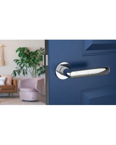 Polished chrome door handle ARIA designer handle front view mounted on an ajar door