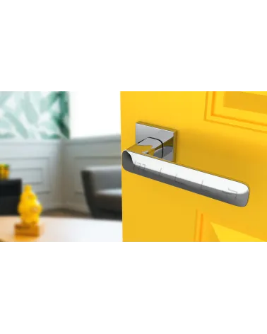 Polished chrome STELLA door handle design handle tilted top view mounted on a door