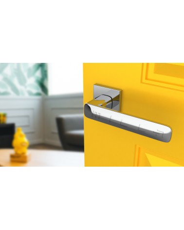 Polished chrome STELLA door handle design handle tilted top view mounted on a door