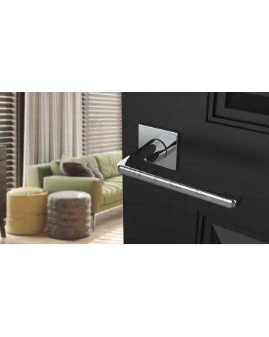 Polished chrome SETIA designer door handle angled top view mounted on a door