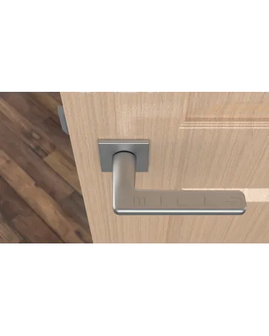 Satin chrome SETIA designer door handle top view mounted on a door