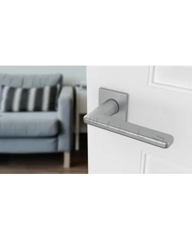 Satin chrome SETIA designer door handle angled top view mounted on a door