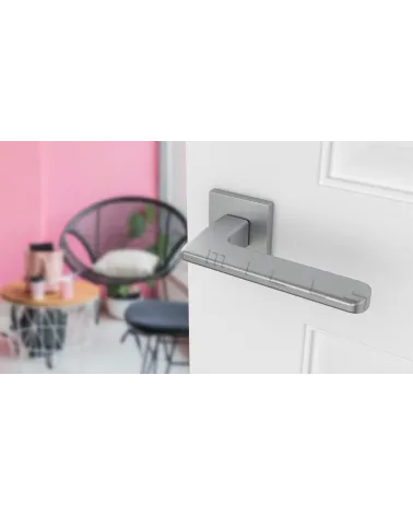 YUKA satin chrome door handle designer hardware angled view mounted on a door
