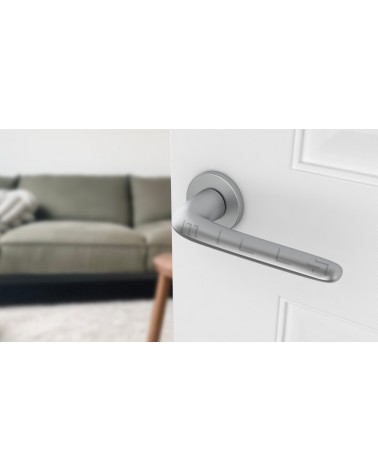 Satin Chrome AZALIA door handle designer handle angled view mounted on a door