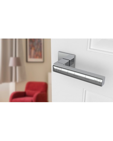 Polished chrome SALICE door handle designer ironmongery angled view mounted on a door