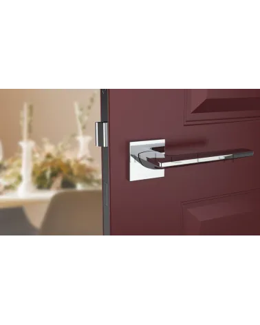 Polished chrome LUNARIA door handle designer handle front view mounted on a door