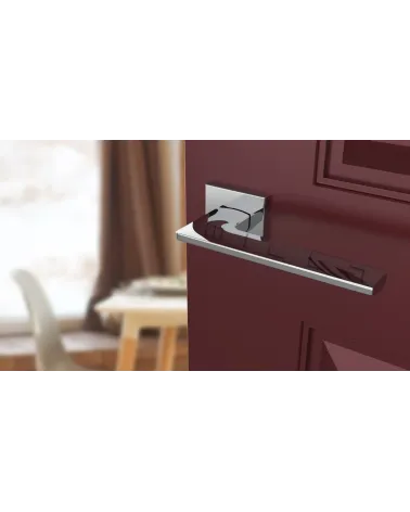 Polished chrome LUNARIA door handle designer handle angled top view mounted on a door