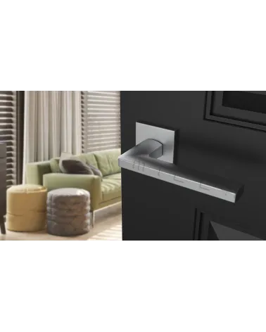 PYROLA satin chrome door handle designer hardware angled view mounted on a door