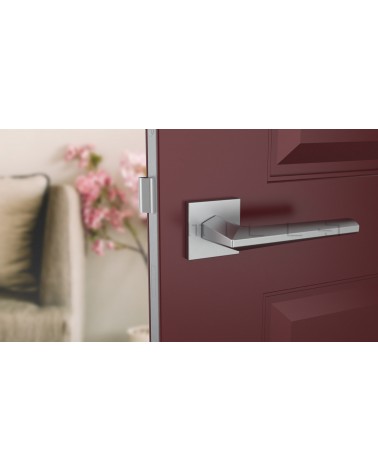 Satin chrome JASMINA door handle designer handle front view mounted on a door