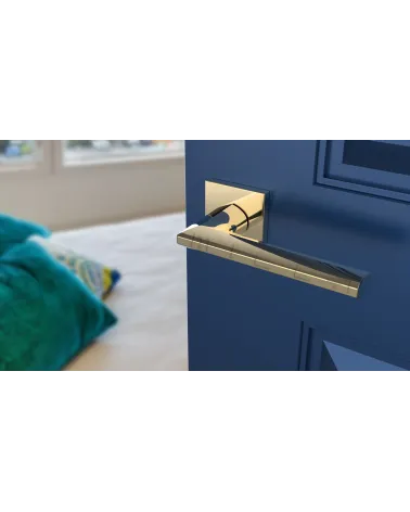 Polished gold JASMINA door handle design handle angled view mounted on a door