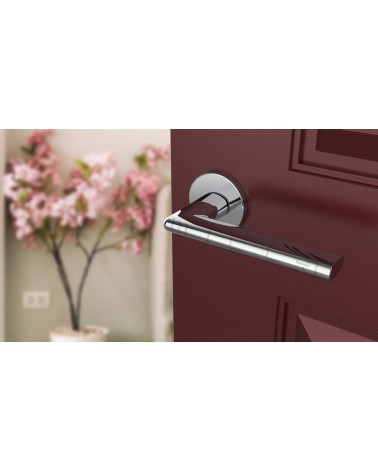 Polished chrome KALMIA door handle design handle angled view mounted on a door