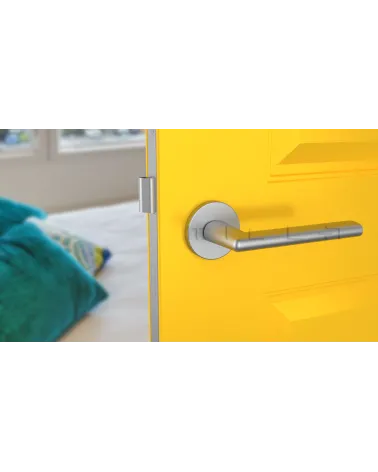KALMIA satin chrome door handle design handle front view mounted on a door