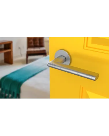 KALMIA satin chrome door handle design handle angled view mounted on a door