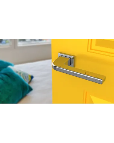 Polished chrome ISMENA door handle design ironmongery angled view mounted on a door