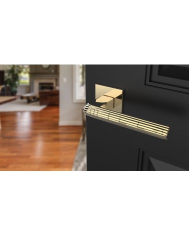 LARICE polished gold door handle design handle angled top view mounted on a door