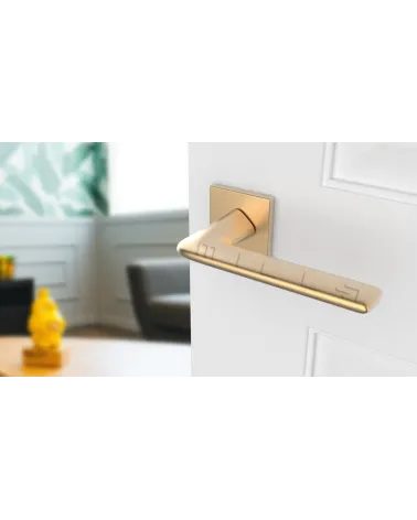 LILA matt gold design door handle angled view mounted on a door