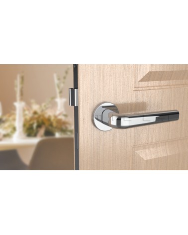 Chrome door handle INULLA designer handle front view mounted on a door