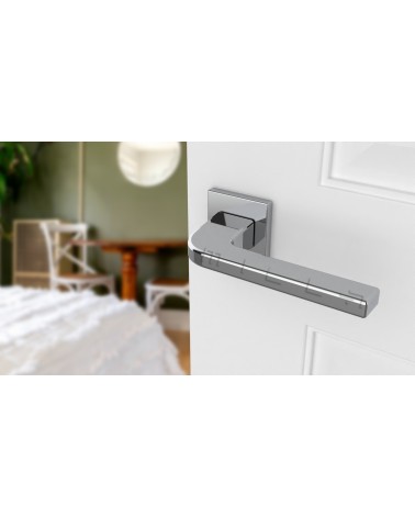 Polished chrome ISMENA door handle designer handle mounted on a half-open door