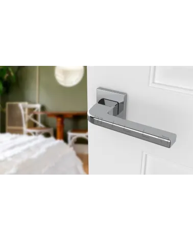 Polished chrome ISMENA door handle designer handle mounted on a half-open door