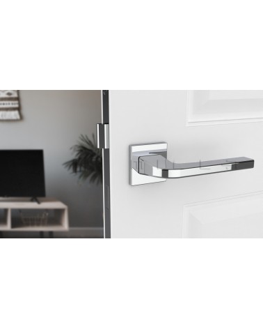 Polished chrome ISMENA door handle designer handle front view mounted on a door