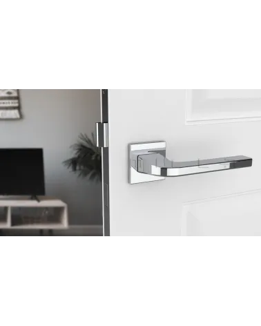 Polished chrome ISMENA door handle designer handle front view mounted on a door