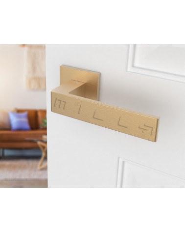 Matt gold Apollo door handle design handle angled view mounted on a door