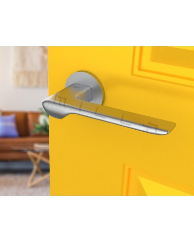 Brushed chrome LIGNE design door handle angled view mounted on a door