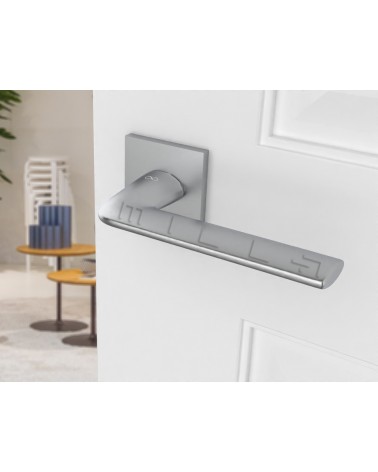 STINGER brushed chrome designer door handle angled view mounted on a door