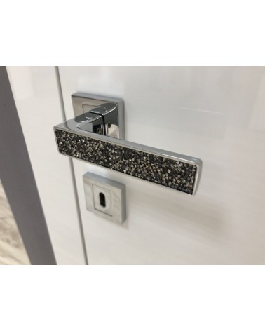 Polished chrome GLAMOUR door handle design ironmongery angled view mounted on a door