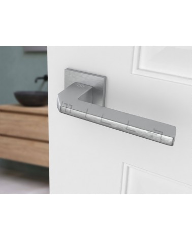 Satin chrome ETNA door handle design hardware angled view mounted on a door