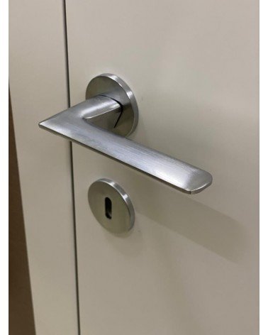 Brushed chrome Line GIULIA door handle design handle slightly angled top view mounted on a door