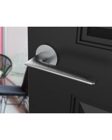 Brushed chrome Line GIULIA door handle design handle angled top view mounted on a door