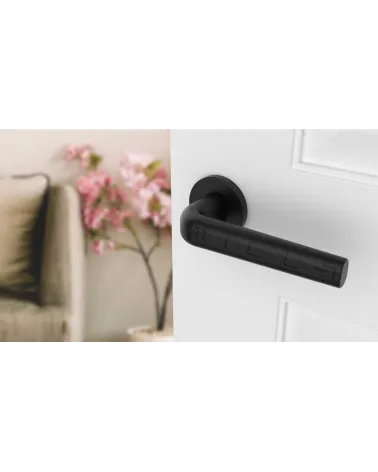 INULLA round plate door handle designer handle angled top view mounted on a door