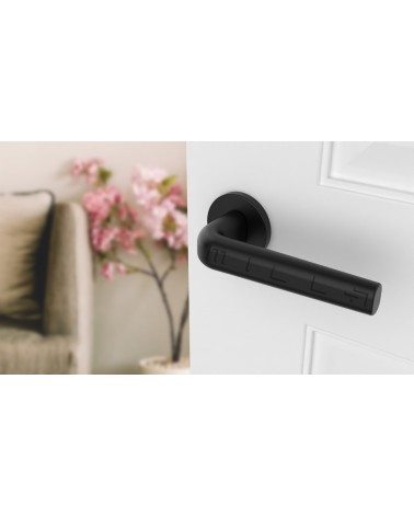 INULLA round plate door handle designer handle angled top view mounted on a door