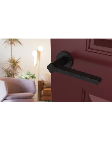 NINFEA door handle on round plate designer hardware angled view fitted on a door