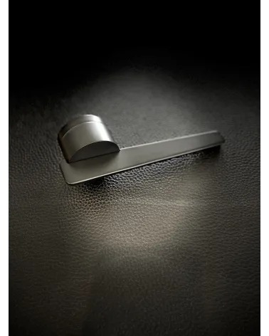 JUMELLE futuristic door handle designer handle placed on a black background