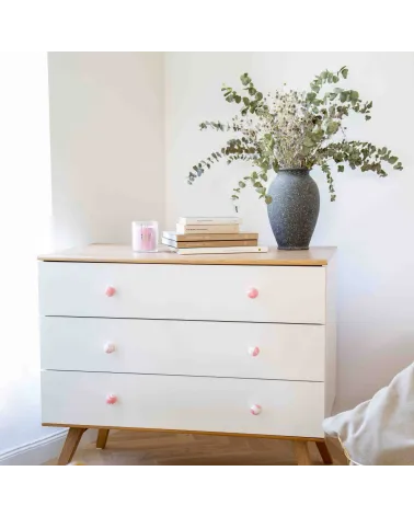Pink beech wood furniture knob design handle fixed on a chest of drawers front