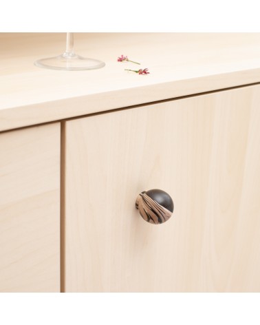 Black chino beech wood furniture knob design handle close-up view mounted on a chest of drawers